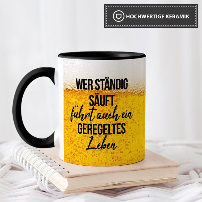 Bier Tasse mit Spruch - Wer st&auml;ndig s&auml;uft f&uuml;hrt auch ein geregeltes Leben - Innen &amp; Henkel Schwarz